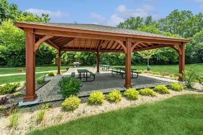 Outdoor pavilion with picnic tables and greenery