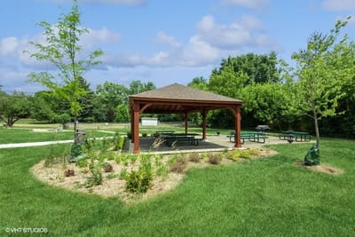 A gazebo in a grassy outdoor area with picnic tables