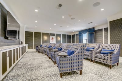 Interior activity room with blue chairs and a screen