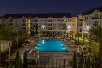 Evening view of a serene pool area surrounded by the facility