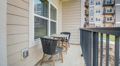 Outdoor balcony with chairs and a small table