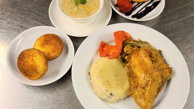 Delicious meal including fried chicken, mashed potatoes, and cornbread