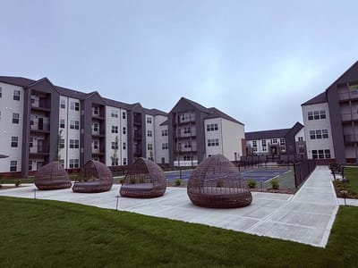 Outdoor seating area with modern architecture in the background.