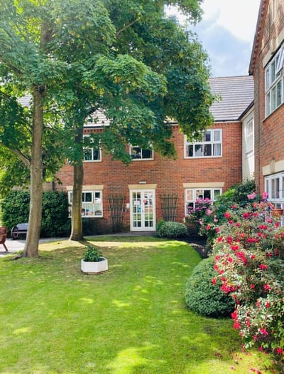 Exterior view of Cedar Court Care Home with garden