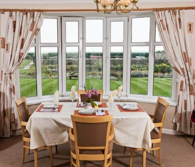 Dining area with large windows and garden view