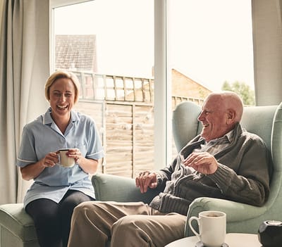 Staff member enjoying tea with a resident.