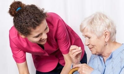 Caregiver assisting an elderly woman with medication