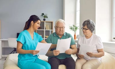 Staff assisting seniors with paperwork in a cozy space.