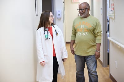 Doctor and patient conversing in a hallway