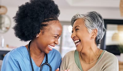 A nurse and resident sharing a joyful moment.