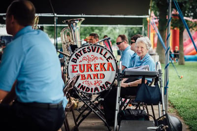 Band members performing outdoors with a visible drum.