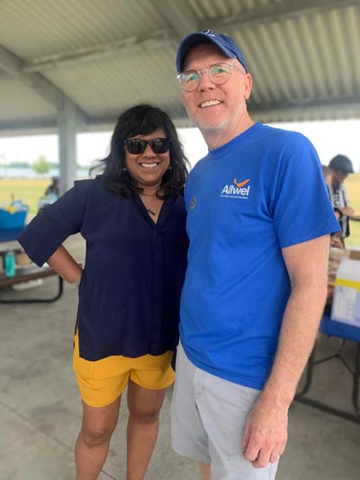Two people smiling at an outdoor event.
