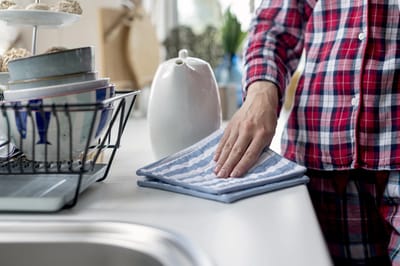 Person wiping down a kitchen countertop