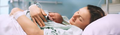 Mount Sinai South Nassau, Nursing Home in Oceanside, NY — Mother cradling newborn baby in a hospital room