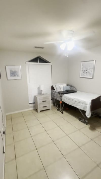 A private resident room with a bed and nightstand.