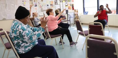 Seniors participating in an exercise activity indoors.