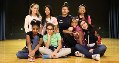 Group of children and staff posing together indoors.
