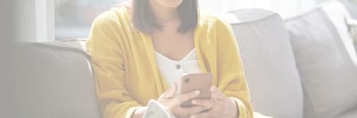Woman in cozy sweater using a smartphone.