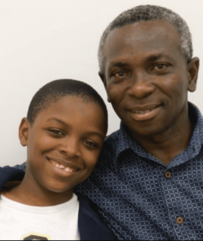 Smiling man and boy posing together.