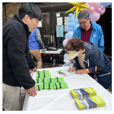 Residents signing in at an outdoor event table.