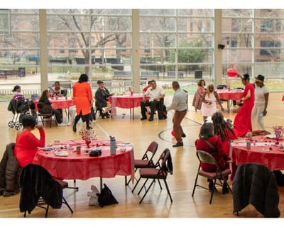 Residents and staff enjoying a celebration in a spacious hall.