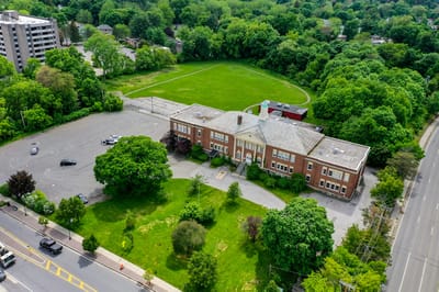 Aerial view of a building and surrounding green space.