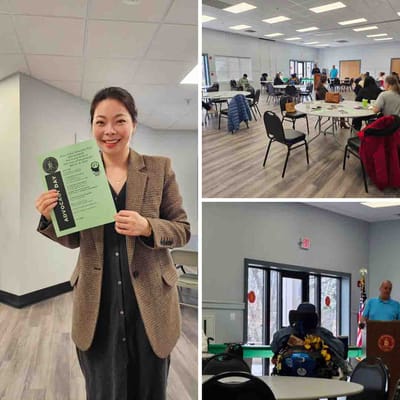 Smiling staff member holding program day flyer in common area.
