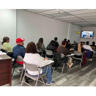 Group of people attending a presentation in a classroom.