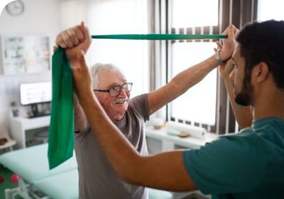 Senior man engaging in physical therapy with assistance