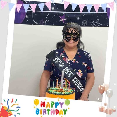Resident celebrating with birthday cake and decorations.