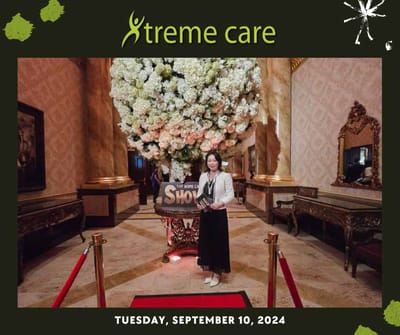 A woman standing near a floral display in a luxurious interior.