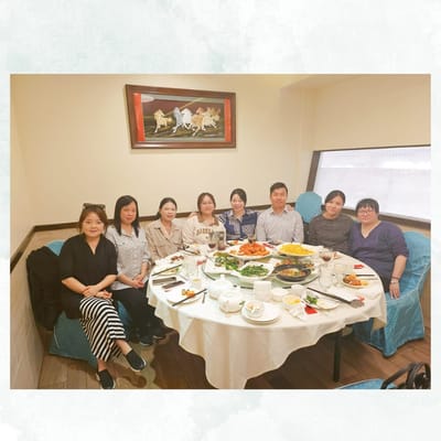 Group dinner with residents and staff at a dining table.