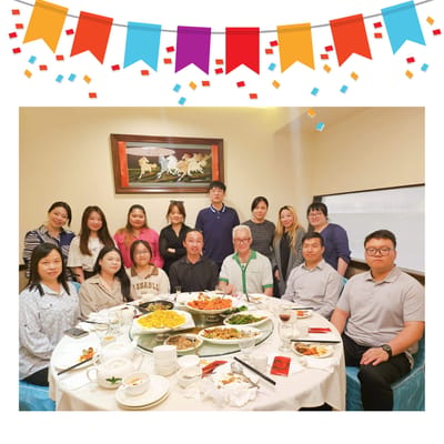 Group of staff and residents at a dining table with food.