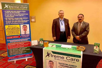 Staff members at a display table with promotional materials.