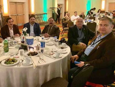 Group of people gathered around a dining table.