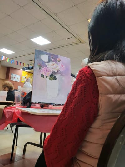 Resident painting flowers in an activity room