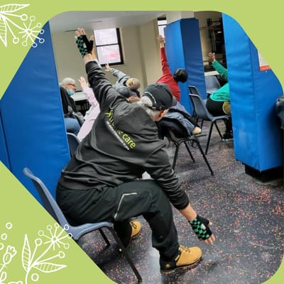 Residents engaged in a seated exercise class.
