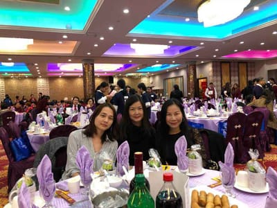 Three women enjoying a meal in a banquet setting