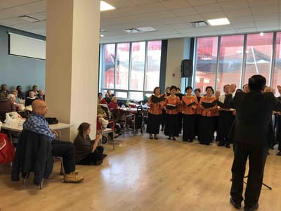 Residents enjoying a choir performance in the common area.