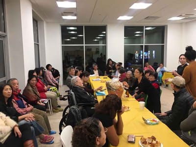 Residents and staff engaged in a shared activity indoors.