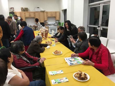 Residents enjoying food and conversation at a common area table.
