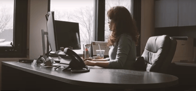Staff member working at a desk in an office.