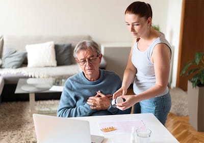 Caregiver assisting an elderly man with medication