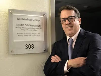 Staff member in front of operation hours sign.