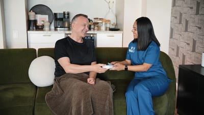 Resident and staff member interacting in a cozy setting.