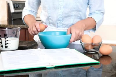 Person preparing eggs in a kitchen