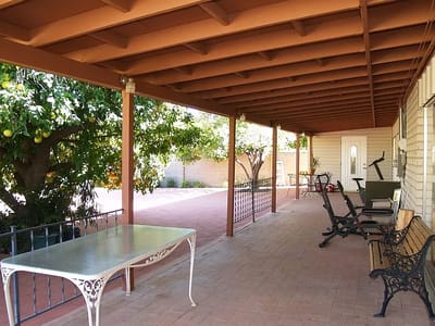Shaded patio area with seating and greenery