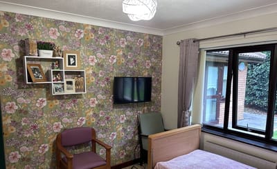 Bright interior of a resident's room with floral wallpaper