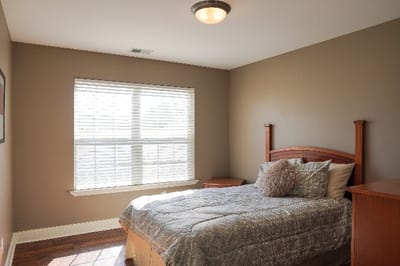 Bright private room with a cozy bed and window.