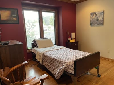 A cozy interior of a resident room with a bed and furniture.